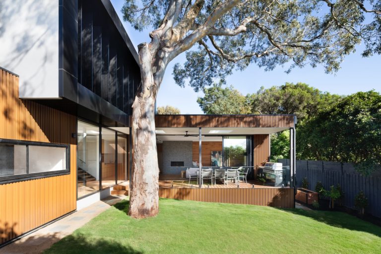 brown and white wooden house near green trees during daytime